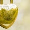 Hinged gold lock in the form of a heart, the inscription love angel with an arrow on a blurred background