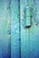 Hinges on old iron door with a shabby turquoise blue, green paint