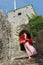 Hippie lady descending a staircase at a ruined English castle on a windy day