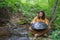 Hippie playing handpan music on the shore of a river