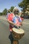 Hippie in red, white and blue tie-dye t-shirt pounds his drum down main street during a Fourth of July parade in Ojai, CA