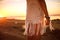 Hippie woman with dark long hair, silver rings with stone and white blouse stands back at sunset. Indie boho vibes and bohemian st