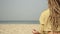 A hippie woman in hair dreadlocks meditates outdoors on the background of sea