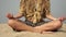 Hippie woman practices yoga and meditation in the lotus position on the seaside