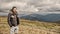 Hipster, bearded man on mountain top on natural cloudy sky