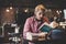 Hipster bearded man reading book in cafe.