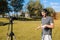 A hipster blogger records a video for a blog with a camera in a park on a sunny day