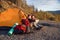 Hipster caucasian couple exploring map in the mountain during sunny day while they are sitting in the tent.