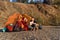 Hipster caucasian lovely couple exploring map and drinks tea or coffee in the mountain while they are sitting in the