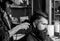 Hipster client getting haircut. Barber with hair clipper works on hairstyle for man with beard, barbershop background