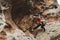 Hipster - climber at the age of climbing up a beautiful rock without insurance and helmet