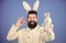 Hipster cute bunny long ears blue background. Easter bunny. Funny bunny with beard and mustache. Join celebration