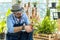 Hipster elderly men take care of the trees, pruning trees with scissors as a hobby of urban home gardening after sustainable