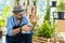 Hipster elderly men take care of the trees, pruning trees with scissors as a hobby of urban home gardening after sustainable