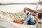 Hipster family on vacation concept, happy woman and man relaxing on a hammock at the beach with their cute bulldog pet, couple