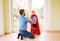 Hipster father with princess daughter in red superhero cape