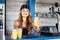 Hipster girl bartender serving fresh lemonade behind counter at outdoor bar during summer festival