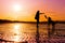 Hipster girl playing with dog at a beach during sunset