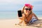 Hipster girl showing something on the phone while lying on the beach