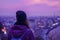 Hipster girl traveler looking at winter evening cityscape, purple violet sky and city lights