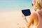 Hipster girl using tablet on the beach