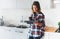 Hipster girl using tablet technology and drink coffee in kitchen interior, person holding computer on background cuisine