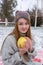 Hipster girl whith a pomelo in knitted sweater and cap