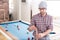 Hipster guy wipes a cue with chalk next to billiard table