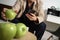 hipster hand using smart phone for mobile payments online business,sitting on sofa in living room,holding green apple in wooden t