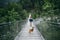 Hipster hiker man and dog on suspension bridge