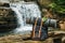 Hipster hiker tourist backpack on the background of the river and the waterfall , traveler relax holiday concept, travel