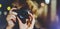 Hipster hiker tourist making photo, holding in hands camera on background of evening atmospheric city, photographer girl enjoying