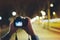 Hipster hiker tourist taking photo on camera on background of evening atmospheric city, photographer guy enjoying light of holiday