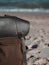 Hipster hiker tourister khaki backpack close up on background blue sea ocean horizon on sand beach, blurred panoramic seascape