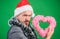 Hipster hold heart symbol of love. Bring love to family holiday. Spread love around. Man in love happy wear santa hat