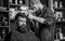 Hipster lifestyle concept. Barber with clipper trimming hair on temple of client. Hipster client getting haircut. Barber