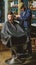 Hipster lifestyle concept. Hipster client getting haircut. Barber with clipper trimming hair on temple of client. Barber