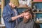 Hipster lifestyle concept. Hipster client getting haircut. Barber with hair clipper work on hairstyle for bearded