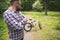 Hipster man standing at park looking at bicycle