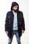 Hipster outfit. Man bearded hipster stand in warm black jacket parka on white. Hipster modern fashion. Guy wear