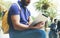 Hipster person holding in hands digital tablet with blank screen, man reading on computer on background nature park palm landscape