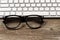 Hipster reading glasses with keyboard on rustic wooden desktop