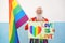 Hipster senior man at gay pride holding rainbow flag and lgbt banner - Focus on face