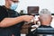 Hipster senior man getting hair cut at vintage barber shop - They both wear face protective masks for coronavirus prevention -