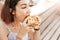 Hipster woman eating a delicious sandwich with a loaf of a checkered Viennese waffle. Modern Street food concept