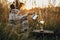 Hipster woman pouring hot water in filter with coffee in glass flask on background of sunny warm light in rural herbs. Alternative