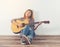 Hipster woman style portrait chilling with guitar look so happy.