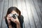 Hipster woman taking photos with retro film camera on wooden floorof city park,beautiful girl photographed in the old camera