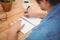 Hipster writing on spiral book at desk