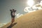 Hipster young girl on slope sandy dune.